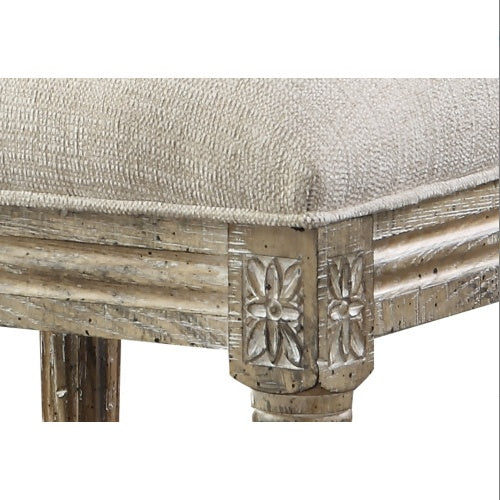 Close-up of a decorative dining chair leg with floral carvings and a textured upholstery seat.
