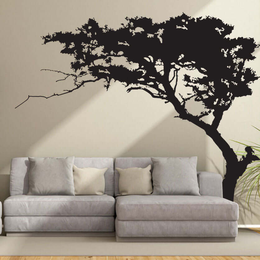 Pine tree large wall sticker in living room with gray sofa, enhancing home decor. Environmentally friendly PVC material, serene forest ambiance.