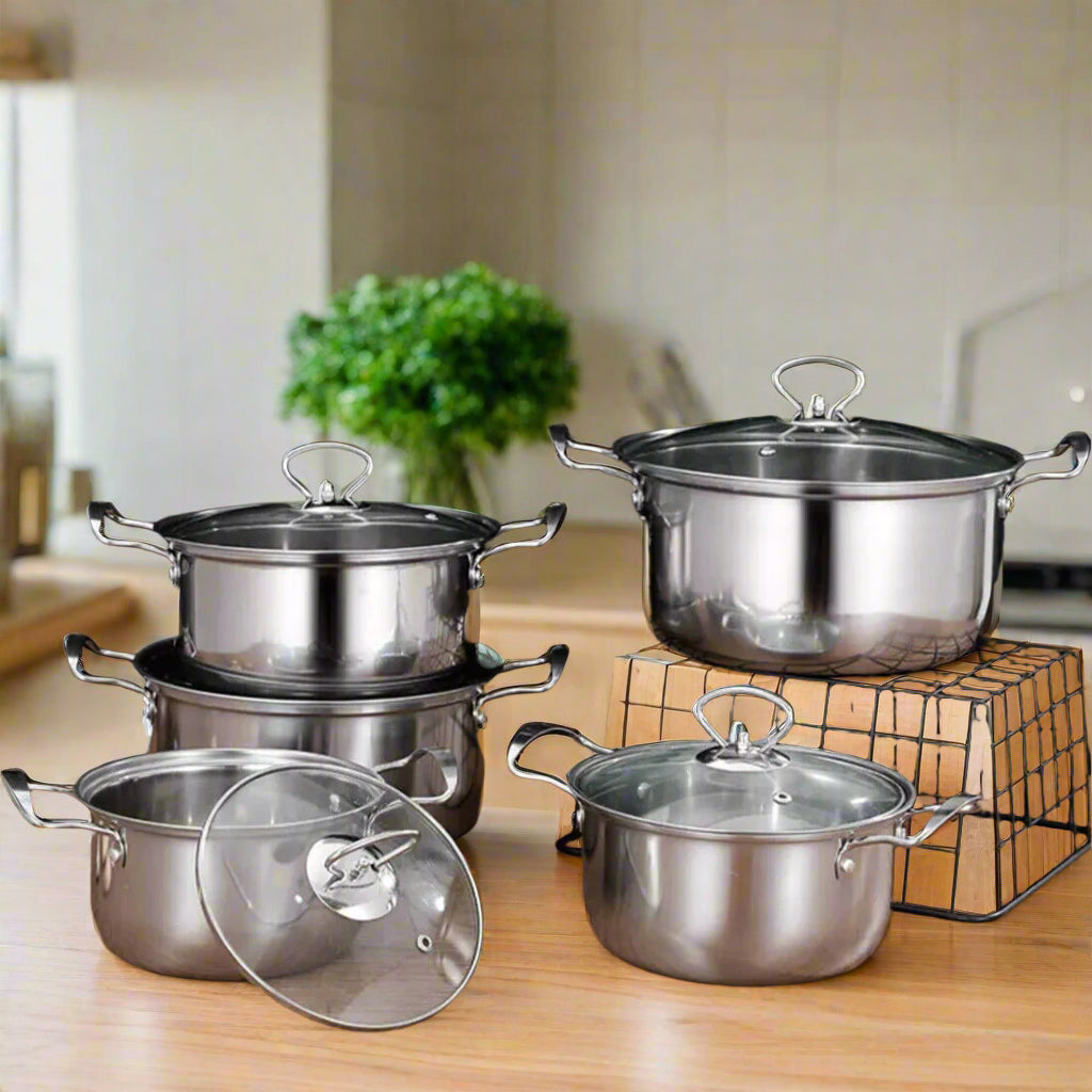 Non-stick stainless-steel cookware set featuring four cooking pots with glass lids, ideal for all stove types.