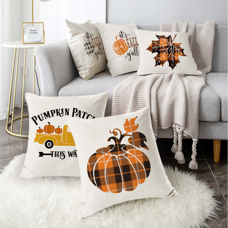 Autumn-themed Thanksgiving pillow covers with pumpkins and fall leaves decor in living room setting.