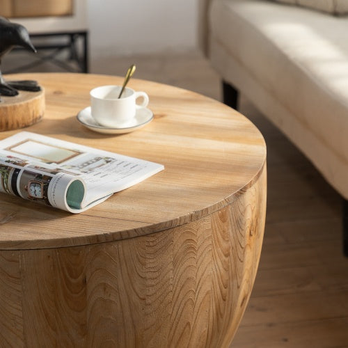 Vintage-inspired round coffee table with magazine and cup, showcasing natural wood grain and modern living room decor.